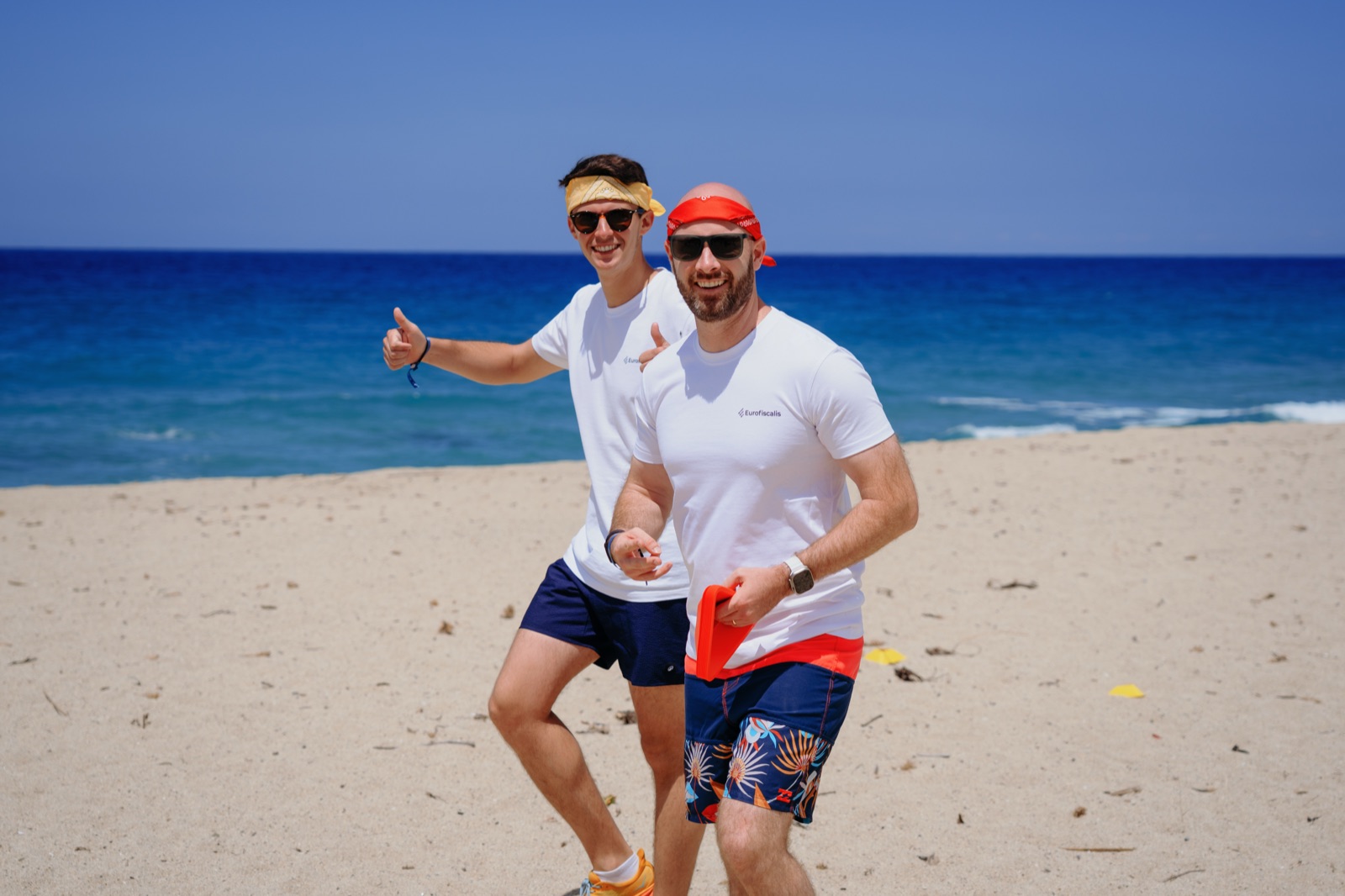 Deux collaborateurs Eurofiscalis en t-shirt sur la plage pendant un séminaire